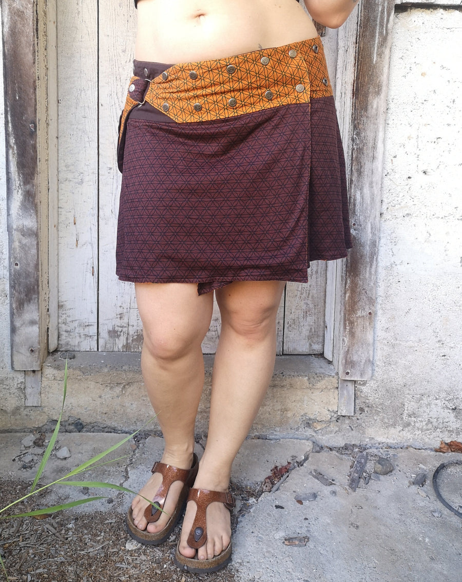 Lower half of body modeling the Chocolate Flower of Life Snap skirt, which has an orange waist belt.