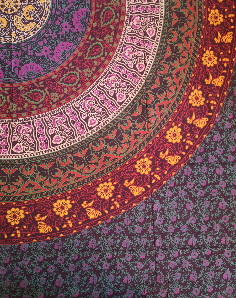 Red purple yellow pink magenta tapestry with circles and flowers, close up